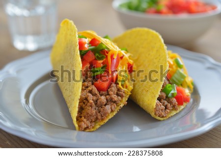 Tacos with ground beef, Cheddar cheese, and vegetables