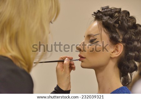NOVOSIBIRSK, RUSSIA - NOVEMBER 15, 2014: Model during makeup application before the fashion parade during Novosibirsk Fashion Week. The event was held under the motto High Fashion & High Classics