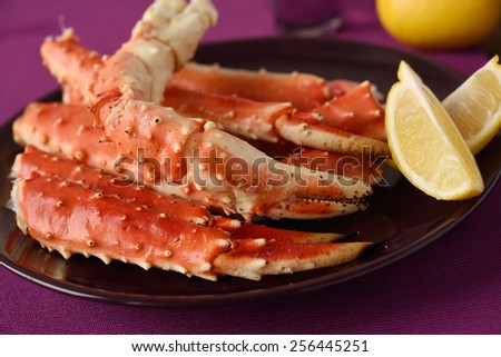 Red king crab legs with lemon on a plate