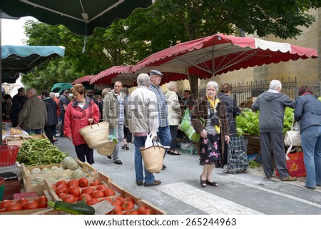 BERGERAC, FRANCE - JUNE 29, 2013: People on the street farmers market on the Market square. Farmers market near the Notre Dame church is open every Wednesday and Saturday