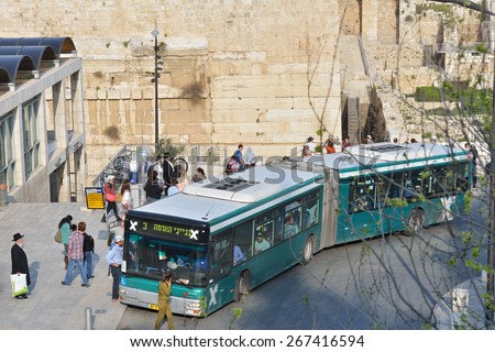 JERUSALEM, ISRAEL - MARCH 20, 2014: People on the bus stop The Western Wall in the Old City. The Old City is listed as UNESCO World Heritage site since 1981.