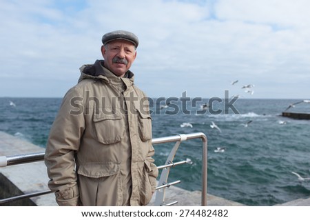 Senior man on the pier against the sea in a springtime day