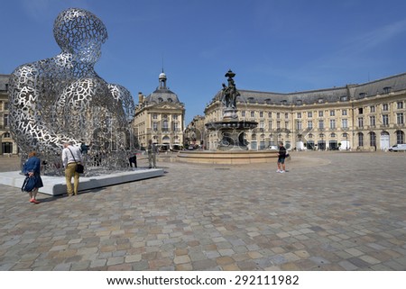 BORDEAUX, FRANCE - JUNE 27, 2013: Tourists in front of the artwork of Jaume Plensa House Of Knowledge against the Fountain of Three Grace on the Place de la Bourse. The fountain was erected in 1869