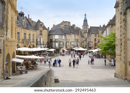 SARLAT, FRANCE - JUNE 28, 2013: Tourist walking in the historic center of old city. Since 2002, the old city of Sarlat included in UNESCO Tentative List