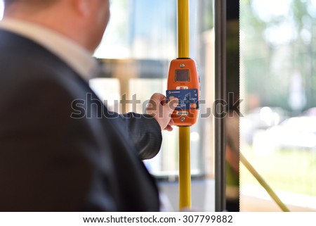 ST. PETERSBURG, RUSSIA - AUGUST 17, 2015: Deputy General Director of Information Networks LTD Kirill Petrenko demonstrate the PayPass technology in transport ticketing system in the line 5 trolleybus