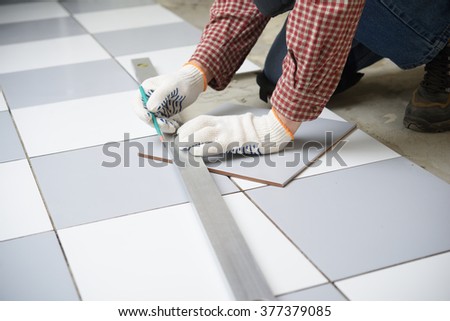 Tiler marks the tile during the floor installation