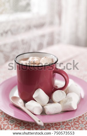 Hot chocolate with marshmallow in pink mug in retro styled kitchen
