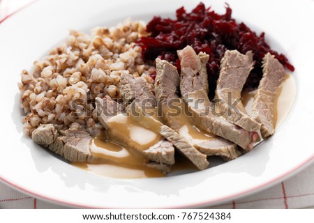 Boiled beef meat with buckwheat porridge, beetroot salad, and cream sauce