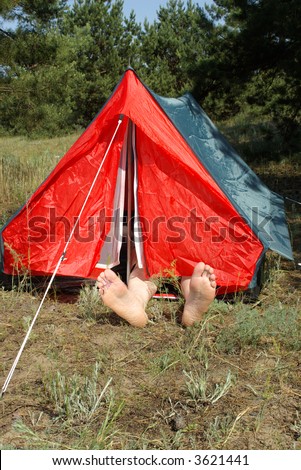 A man resting in tent with his feet in the warm sun