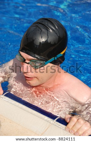 man wearing goggles swimming in pool