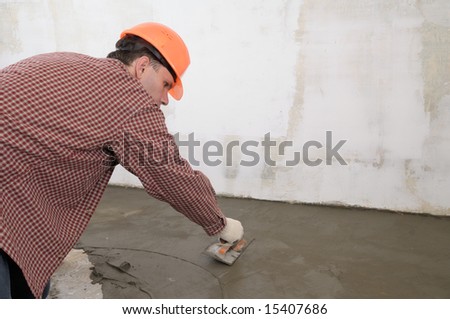 Construction worker spreading wet concrete