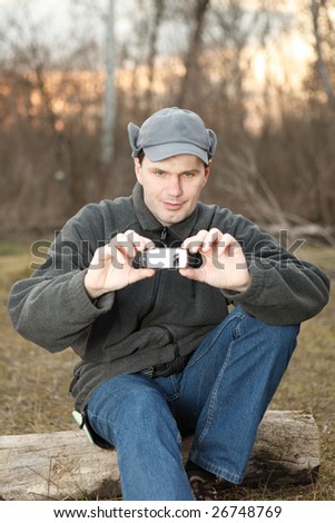 Man making photo with mobile phone in spring forest