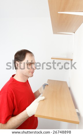 Man installing the shelf on angle brackets