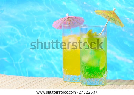 Mojito and Daiquiri cocktails against turquoise water background