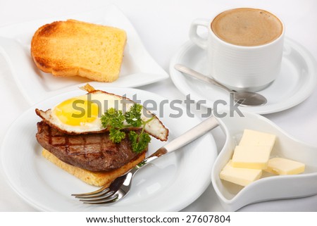 American breakfast with fried eggs, grilled meat, toasts, butter, and coffee
