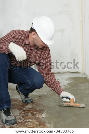 Construction worker spreading wet concrete