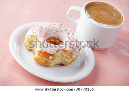 Taken a bite donut and a cup of coffee