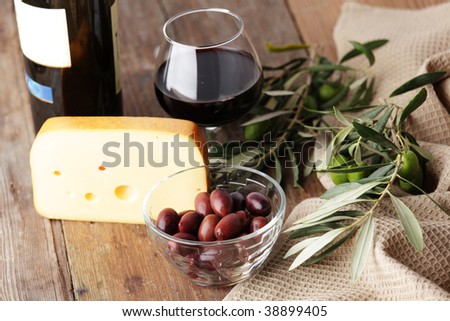 Yellow cheese, olives, and red wine