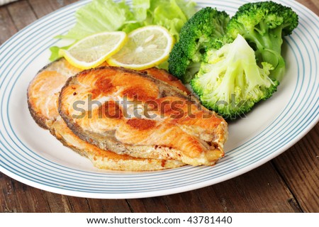 Roasted salmon steaks with broccoli, lemon, and lettuce