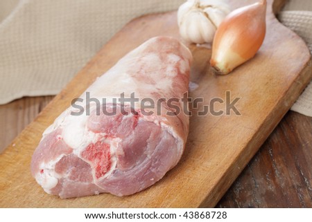 Raw pork leg for eisbein on a chopping board