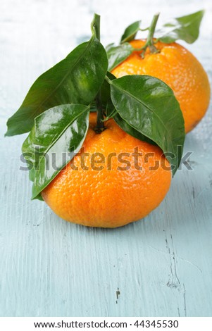 Mandarin oranges with leaves on a wooden table