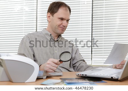 Man with laptop printing photos on the printer