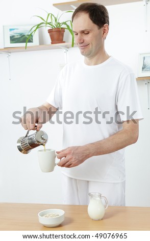 Man pouring tea in a cup for breakfast