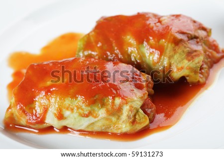 Stuffed cabbage with tomato sauce on white plate