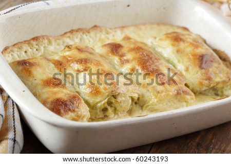 Stuffed cabbage under bechamel sauce in white casserole