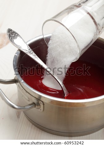 Pouring sugar into the red currant syrup