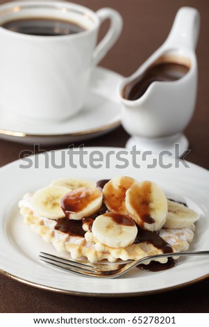 Waffle with banana under chocolate sauce closeup