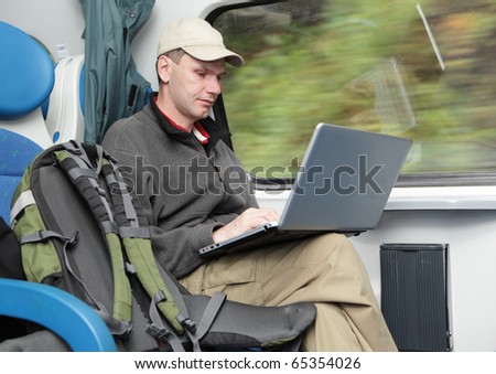 Tourist with backpack and laptop in the train