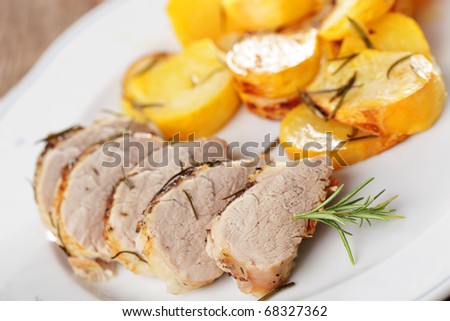 Pork tenderloin with baked turnip and rosemary on white plate