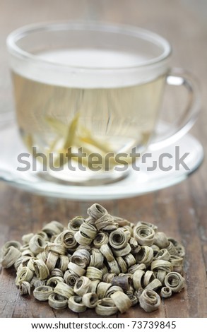 Dried tea leaves and white Jade ring tea on the rustic table
