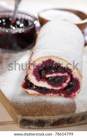 Swiss roll with black currant jam under powdered sugar