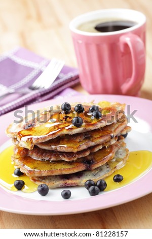 Stack of blueberry pancakes with honey and black coffee