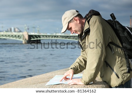 Tourist looking to the city map on the quay of Neva river in St. Petersburg, Russia