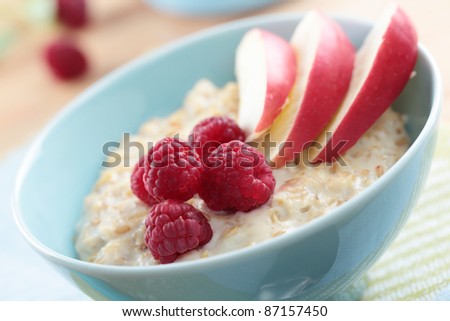 Oatmeal porridge with raspberry and apple in a bowl