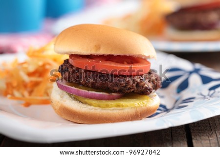 Mini hamburgers with coleslaw on paper plates