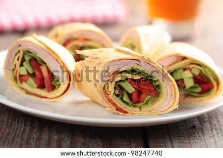 Tortilla roll-ups with ham, cheese, avocado, and pepper