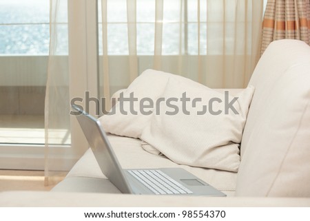 Laptop on a sofa against a window
