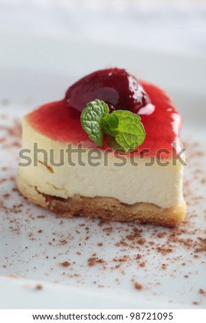 Heart-shaped slice of cheesecake with cherry jam