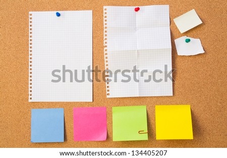 Colour note papers on pin board. Cork background