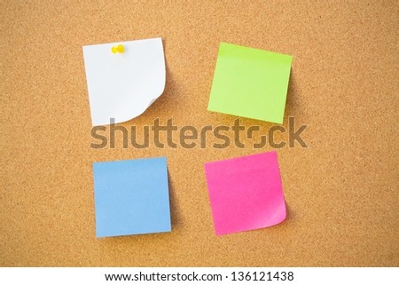 Colour note papers on pin board. Cork background