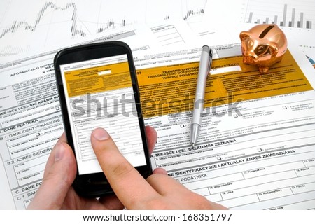 Man hand filling polish income tax form with mobile application