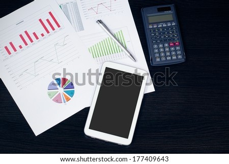 Tablet in office, business composition on desk top view