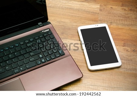 Cell phone and tablet with blank display od wooden background