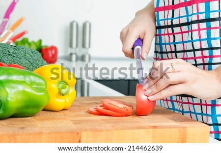 Woman chef cutting peppers. Food preparation in modern kitchen