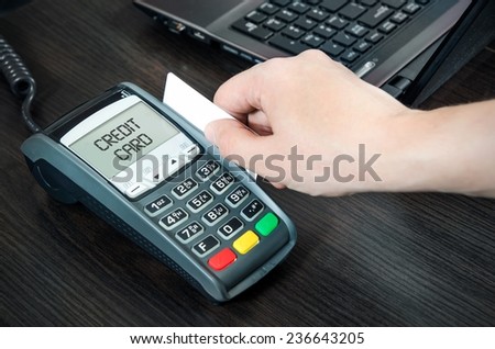Man pays with credit card. Swiping plastic card through terminal
