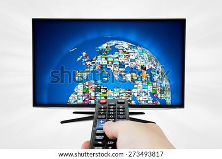 Widescreen high definition TV screen with sphere video gallery. Remote control in hand